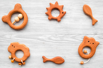 Cute wooden handmade toys for newborn on grey wooden background top view copyspace