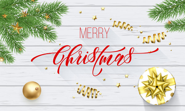 Merry Christmas golden decoration and calligraphy font on white wooden background for greeting card. Vector Christmas or New Year gold shiny star on Xmas tree for winter holiday premium design