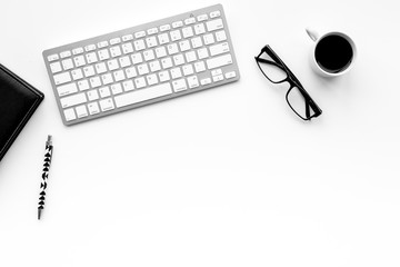 Stylish office desk. Trendy monochrome. Black notebook, glasses, pen and  coffeee on white background top view copyspace