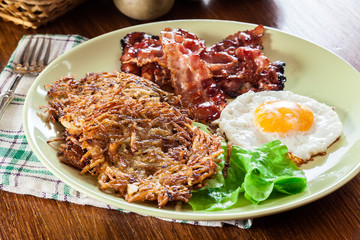 Hash browns. Potato pancakes with crispy fried bacon and fried egg