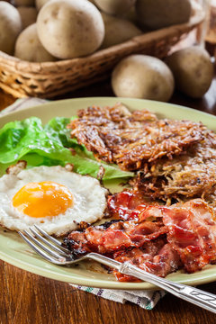 Hash browns. Potato pancakes with crispy fried bacon and fried egg