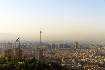 Tehran city skyline with Iranian flag and Milad Tower (Borj-e Milad landmark, hight 435 m.), seen...