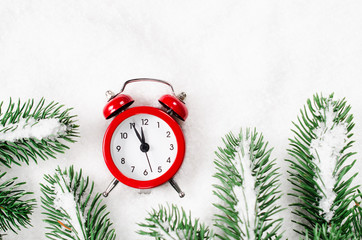 New Years clock and snow-covered fir branches.