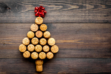 Corks of wine bottles in shape of new year spruce on dark wooden background top view copyspace