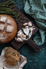 Beautiful serving bread and garlic on dark wooden background