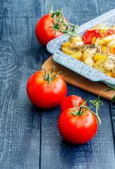 ripe tomatoes and stewed potatoes on a blue bacground