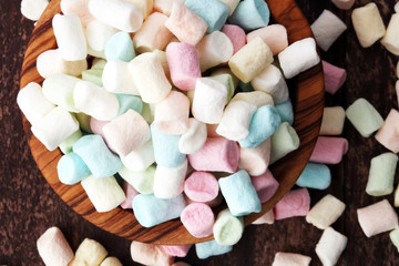 Colorful mini marshmallows on wooden background in bowl