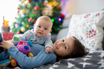 Six years old preschool boy, playing at home with his newborn baby brother