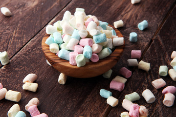 Colorful mini marshmallows on wooden background in bowl