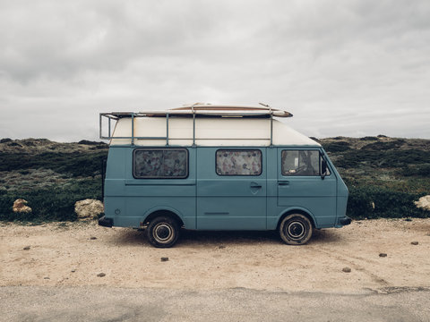 Camber in blue at a beach with Surfboards on the roof