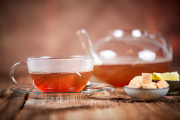 Hot russian tea in cup and teapot and brown sugar cubes and lemon