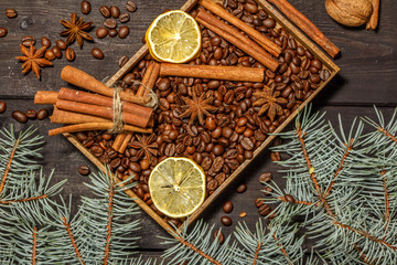Fototapeta na wymiar Christmas background decoration with grains of coffee, cinnamon, anise, lemon and spruce branches. View from above.