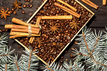 Christmas background decoration with grains of coffee, cinnamon, anise, lemon and spruce branches. View from above.