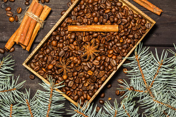 Christmas background decoration with grains of coffee, cinnamon, anise, lemon and spruce branches. View from above.