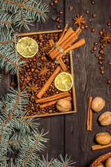 Christmas background decoration with grains of coffee, cinnamon, anise, lemon and spruce branches. View from above.