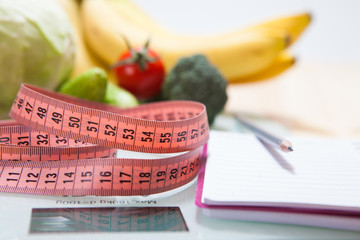 Healthy diet, fitness and weight loss concept, scales, measuring tape, fruits, vegetables on the table.