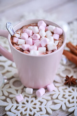 Pink mug of hot chocolate with marshmallows on table, top view