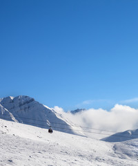 Fototapeta na wymiar Gondola lift and snowy ski slope