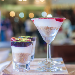 Blueberry and strawberry cheese tart contain in two style of glasses, display on wooden block for sale with blur background, food and dessert business marketing and advertising concept.