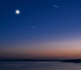 Fototapeta na wymiar Moon and stars over the calm sea.
