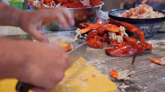 Family prepare fresh lobster for their dinner at a home