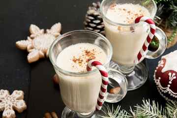 Eggnog, winter Christmas traditional hot drink with milk, eggs, rum. Christmass New Year decoration with gingerbread cookies.