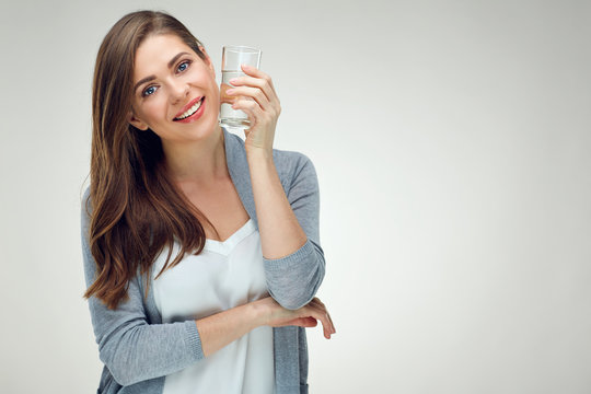 Portrait of smiling woman with long hair holding water glass.