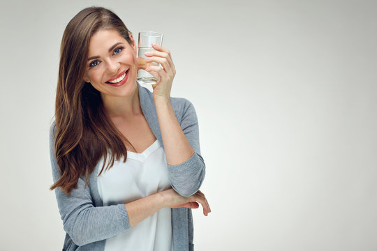Young smiling woman holding water glass. Isolated studio portrait