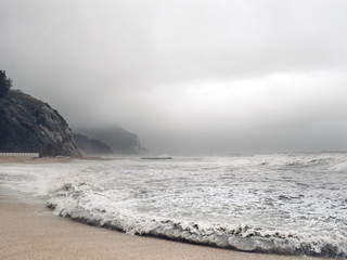 Stürmische Meerlandschaft Küste an einem stürmischen Tag mit Felsen Bergen und Meer im Hintergrund
