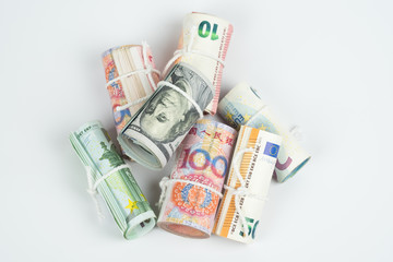 Obraz na płótnie Canvas Currencies and money exchange trading concepts. The rolls of different currencies US Dollar, Euro and Chinese yuan banknotes isolated on white background.