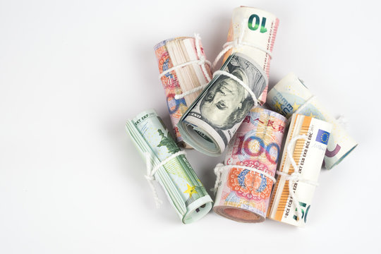 Currencies and money exchange trading concepts. The rolls of different currencies US Dollar, Euro and Chinese yuan banknotes isolated on white background.