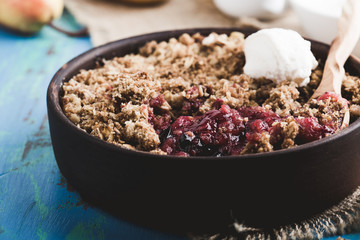 Pear and berry crumbles served with cream