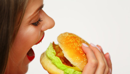 Close up portrait of woman face biting hamburger.