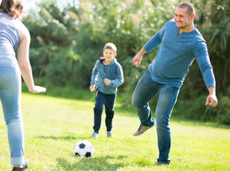 Smiling son and parents playing football