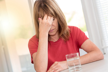 Mature woman having a headache, light effect