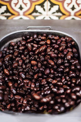Black olives.  Background with olives with oil in a container on market stall.