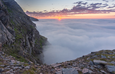 Sunset in the fog on the rocks of Soroya Island, Norway