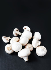 Fresh Mushroom champignon on dark   background, sliced and whole with copy space, ready for cooking