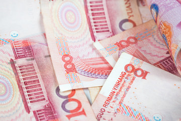 Closeup Chinese yuan bills. Yuan is the currency of China, Selective focus on stack of one hundred Chinese yuan banknotes for money background.
