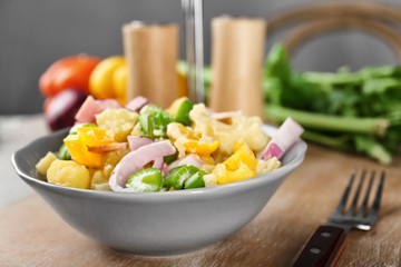 Bowl with delicious potato salad on table
