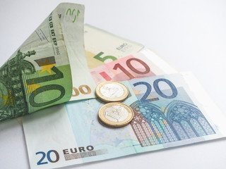 Euro banknotes and coins on white background.
