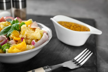 Bowl with delicious potato salad on table