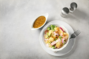 Composition with delicious potato salad and mustard sauce on table