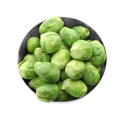 Fototapeta premium Fresh Brussels sprouts in metal bowl on white background