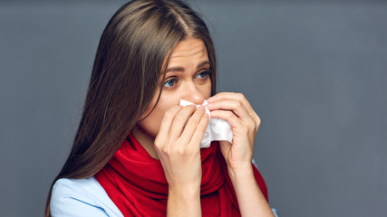 Sickness woman blow on nose in paper tissue.