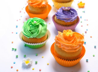 Tasty colorful cupcakes on white background
