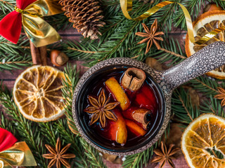 Christmas mulled wine with cinnamon, orange and star anise in a ceramic bowl with winter decorations © Elenglush