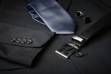 Elegant tie, cuff links and belt on male jacket, closeup