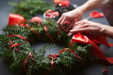 mom makes a Christmas wreath with her own hands