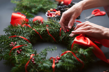 mom makes a Christmas wreath with her own hands © Mykhailovskyi